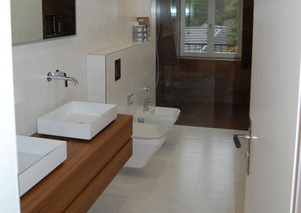 Modernes Badezimmer mit Holzwaschtisch, zwei Waschbecken und bodengleicher Dusche.